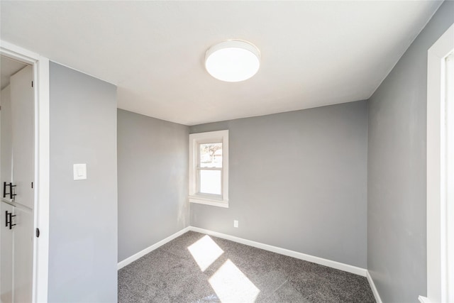 carpeted spare room featuring baseboards