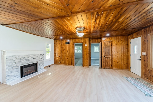 unfurnished living room featuring light wood-type flooring, wood ceiling, wood walls, and a fireplace