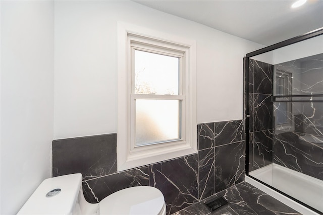 full bath featuring tile walls, toilet, marble finish floor, and a marble finish shower