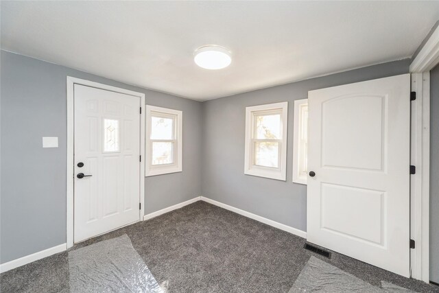 carpeted entrance foyer with visible vents and baseboards