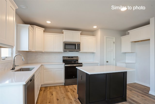 kitchen with a center island, sink, light hardwood / wood-style floors, and stainless steel appliances