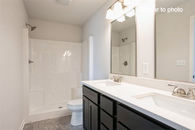 bathroom featuring toilet, a shower, and vanity