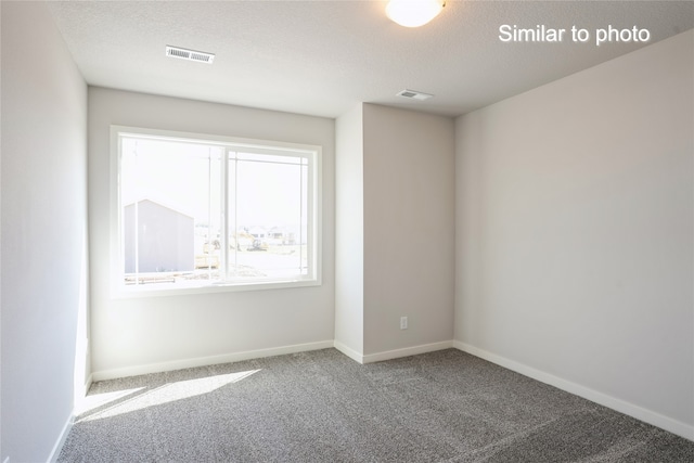 carpeted empty room with a textured ceiling