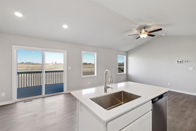 kitchen with sink, vaulted ceiling, a center island with sink, dishwasher, and white cabinets