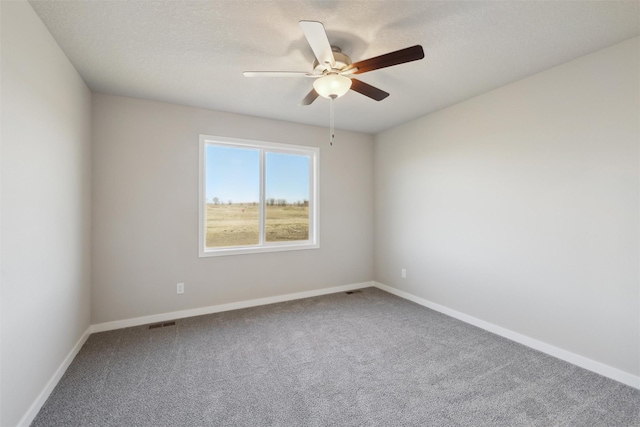 spare room with a textured ceiling, ceiling fan, and carpet