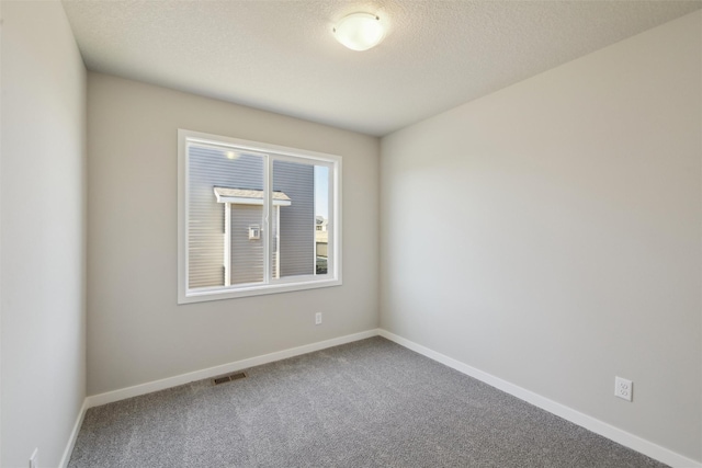 carpeted empty room with a textured ceiling