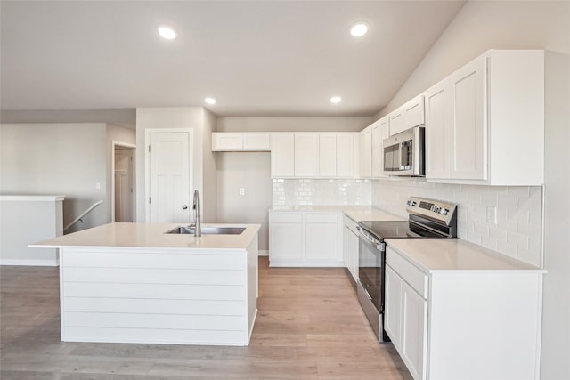 kitchen featuring stainless steel appliances, decorative backsplash, white cabinetry, and sink