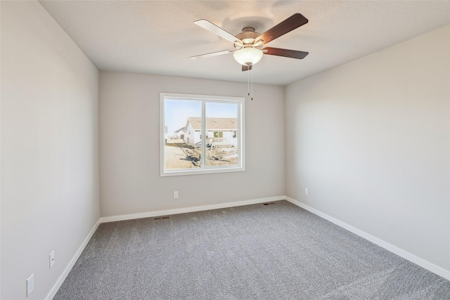 carpeted spare room featuring ceiling fan