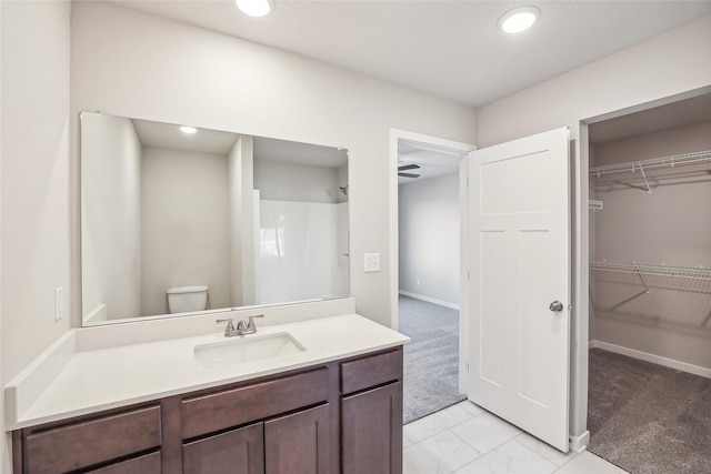 bathroom featuring toilet, vanity, ceiling fan, tile patterned floors, and a shower