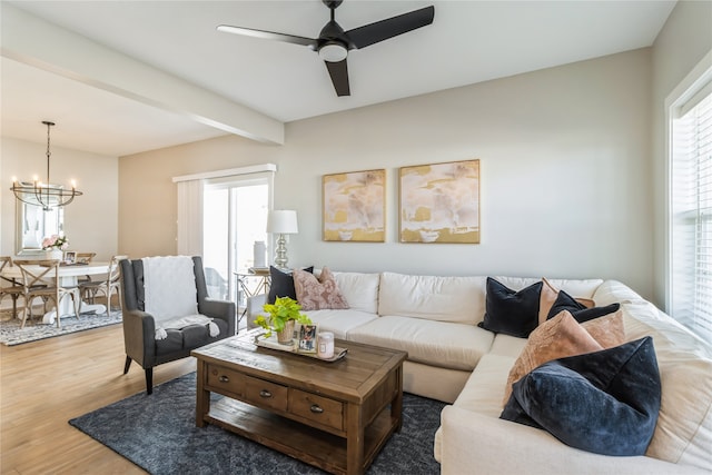 living room with wood-type flooring, beamed ceiling, and ceiling fan with notable chandelier