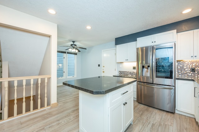 kitchen with decorative backsplash, white cabinetry, light wood-type flooring, and stainless steel refrigerator with ice dispenser