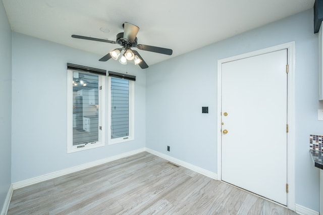 spare room with ceiling fan, baseboards, and wood finished floors