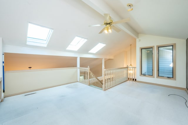 additional living space featuring vaulted ceiling with beams, a ceiling fan, visible vents, and carpet floors