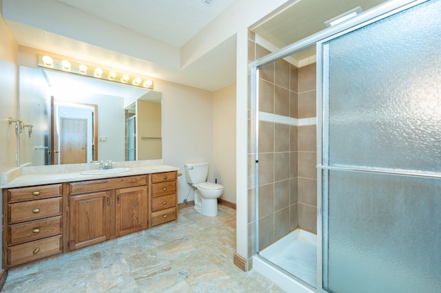 full bathroom with vanity, a shower stall, toilet, and baseboards