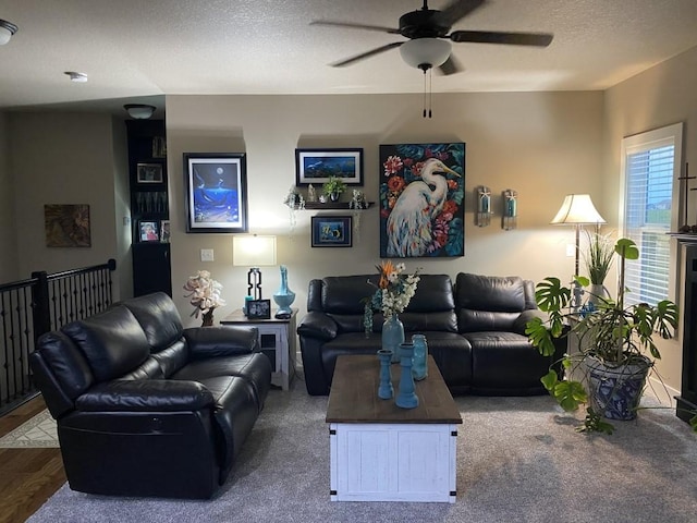 living room with a textured ceiling, hardwood / wood-style flooring, and ceiling fan