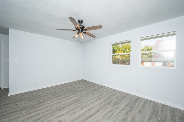 empty room with hardwood / wood-style flooring, ceiling fan, and a textured ceiling