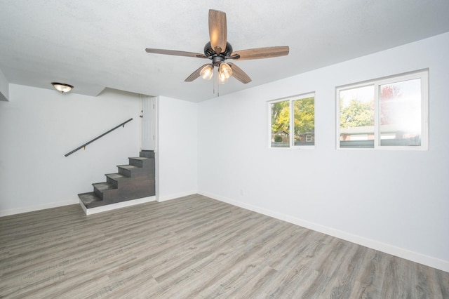 empty room featuring a textured ceiling, light hardwood / wood-style floors, and ceiling fan