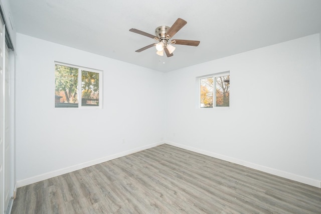 unfurnished room featuring hardwood / wood-style floors, a wealth of natural light, and ceiling fan