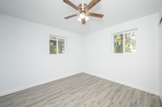 spare room with ceiling fan and light wood-type flooring