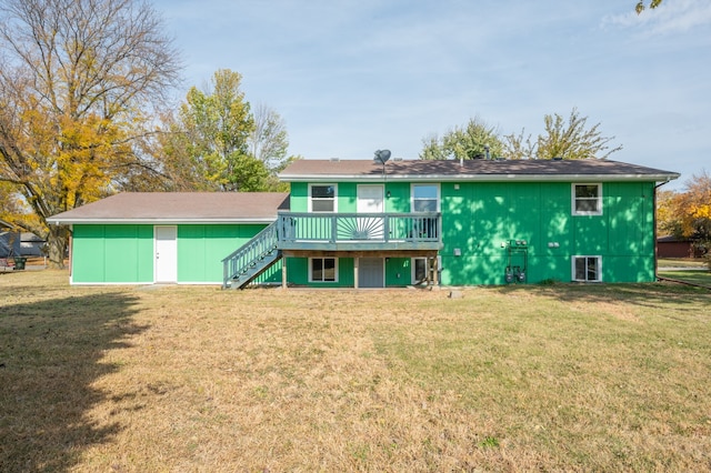 rear view of house featuring a wooden deck and a yard