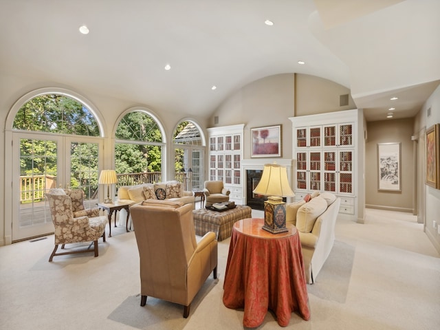 living room featuring vaulted ceiling, a wealth of natural light, and light colored carpet