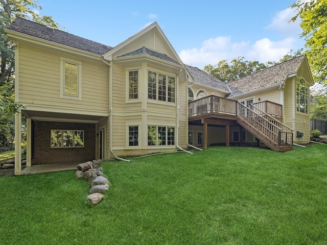 back of property featuring a deck and a lawn