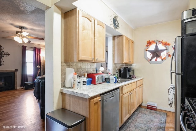 kitchen featuring appliances with stainless steel finishes, dark hardwood / wood-style flooring, ceiling fan, decorative backsplash, and light brown cabinets