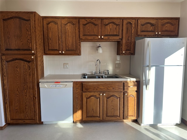 kitchen featuring decorative backsplash, sink, and white appliances