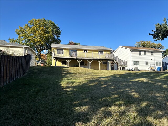 back of property with a yard and a deck