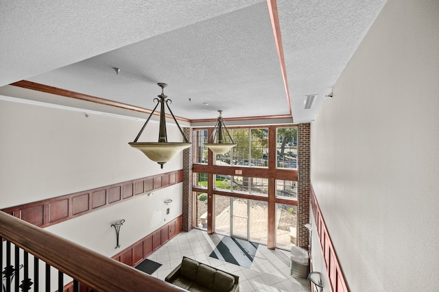 stairway with ornamental molding and a textured ceiling