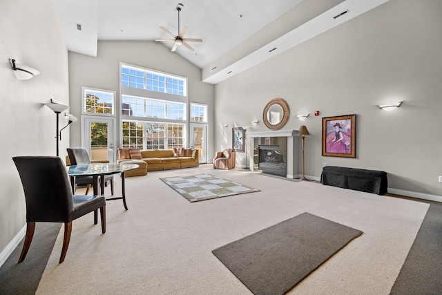 living room featuring ceiling fan, high vaulted ceiling, carpet floors, and a fireplace