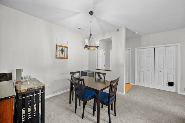 carpeted dining area featuring a notable chandelier