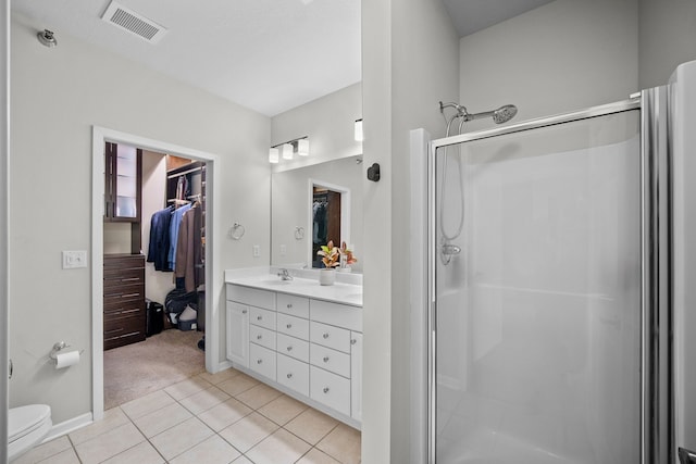 bathroom featuring vanity, tile patterned floors, toilet, and walk in shower