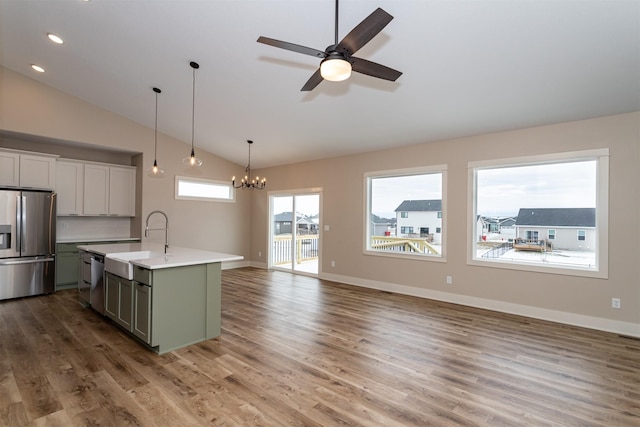 kitchen featuring dark hardwood / wood-style floors, sink, an island with sink, stainless steel appliances, and ceiling fan with notable chandelier