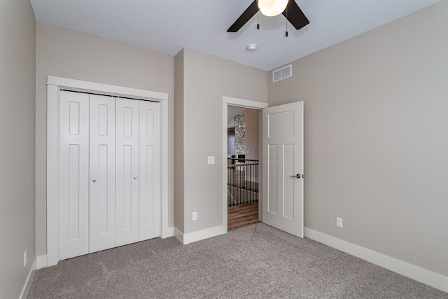 unfurnished bedroom featuring ceiling fan, a closet, and carpet floors