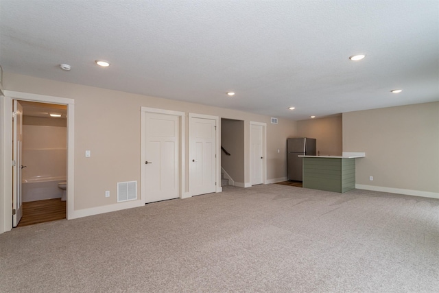 interior space with light carpet and a textured ceiling