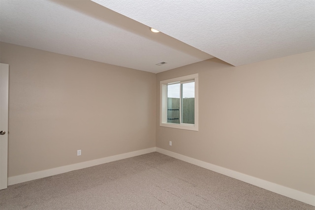 carpeted spare room featuring a textured ceiling