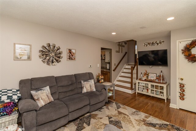 living room featuring a textured ceiling and dark hardwood / wood-style flooring