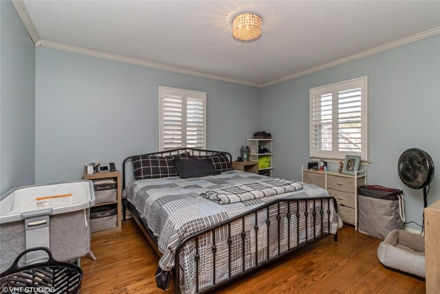 bedroom featuring wood-type flooring and ornamental molding