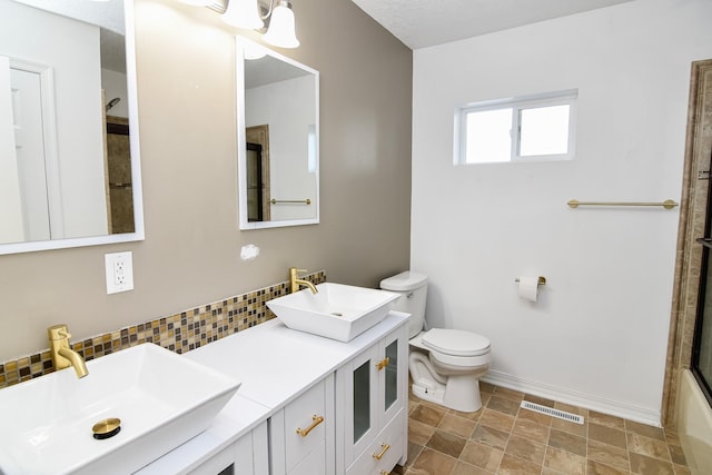 full bathroom featuring vanity, toilet, bath / shower combo with glass door, and tasteful backsplash