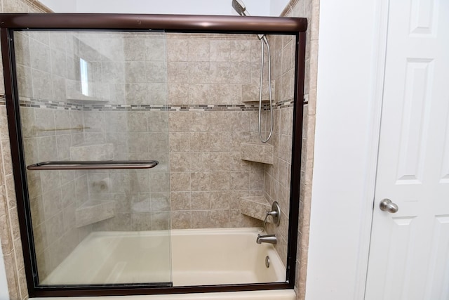 bathroom featuring bath / shower combo with glass door