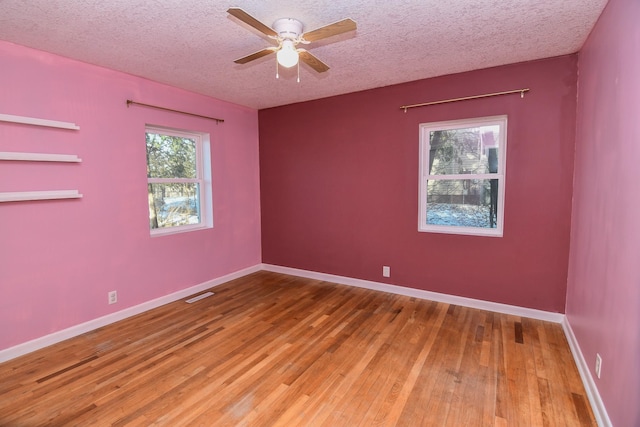 unfurnished room with hardwood / wood-style flooring, ceiling fan, and a textured ceiling