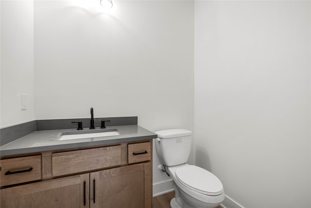 bathroom featuring vanity, toilet, and wood-type flooring