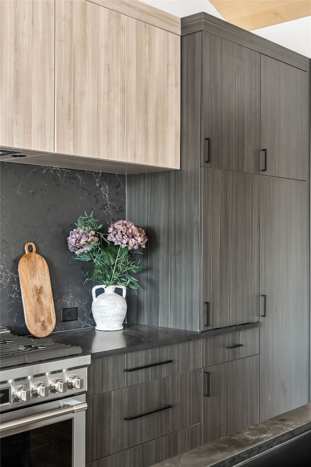 interior space with decorative backsplash, stainless steel range, and light brown cabinets