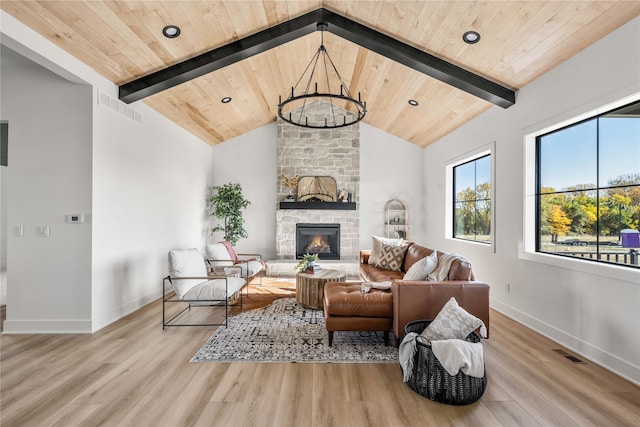 living room with a stone fireplace, a chandelier, wooden ceiling, and light wood-type flooring