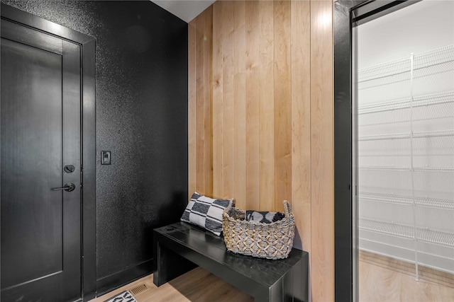 mudroom featuring wood walls and light hardwood / wood-style flooring