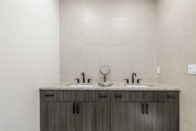 bathroom featuring vanity and tile walls