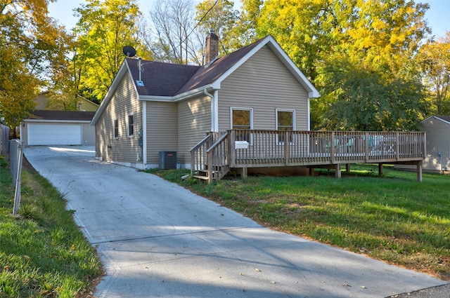 view of front facade featuring a front yard, a garage, a deck, and an outbuilding