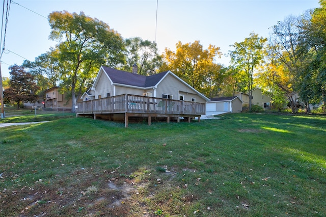 back of house with an outbuilding, a deck, and a yard