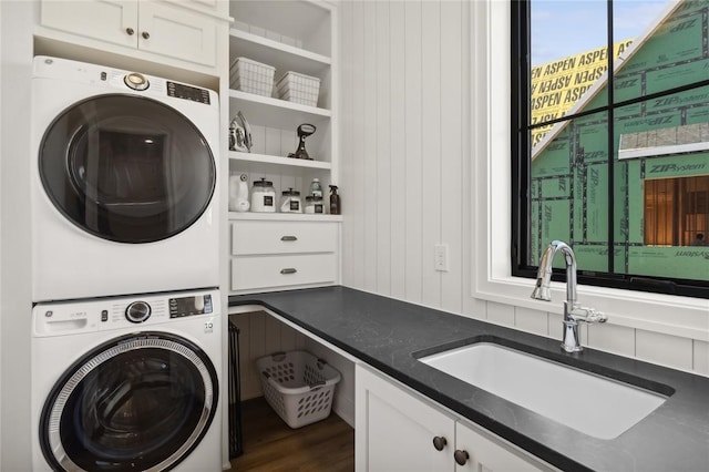 1517 SW Des Moines St, Ankeny, IA 50023 - clothes washing area featuring dark wood-type flooring, stacked washer / drying machine, cabinet space, and a sink